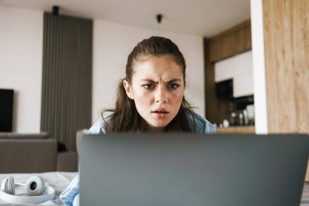 Displeased angry girl using laptop computer